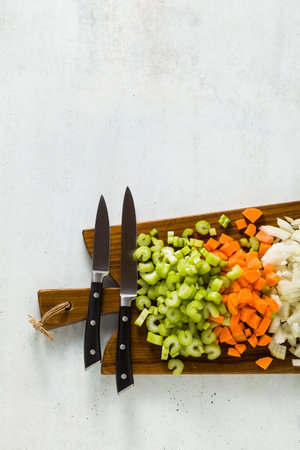 chopped vegetables and a chef's knife on a wooden cutting board. Basic cutting for restaurants or home cooking.の写真素材