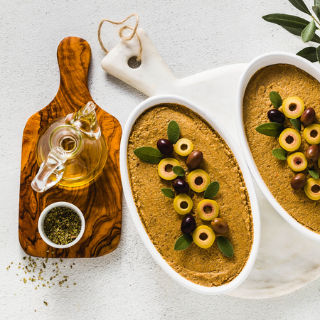 vegan olives pate on a table with a branch of olive tree. healthy vegan cuisine for parties and holidays. Tapenadeの写真素材