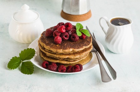 gluten-free green buckwheat pancakes with fresh berries and maple syrup. Delicious vegan breakfast without eggs, flour and refined sugar. healthy food for the whole family. Moka pot with morning coffeeの写真素材