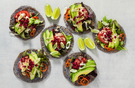Gluten-free vegan tacos from black bean  with tomato and avocado salad  with tahini sauce and pomegranate seeds. healthy fast food for the whole family or partyの写真素材