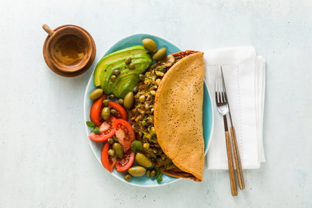 vegan breakfast of gluten-free egg-free chickpea omelet with fried mushrooms and leek. and a salad...