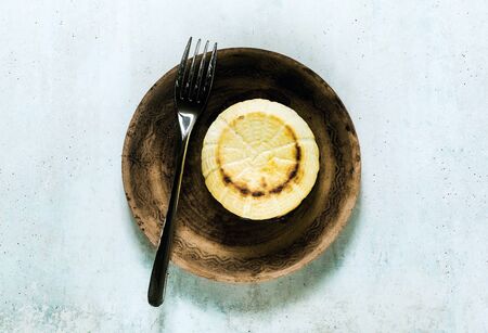 Oven baked ricotta cheese on a clay plate and fork. basic cooking techniques of Italian cuisine. breakfast.の写真素材