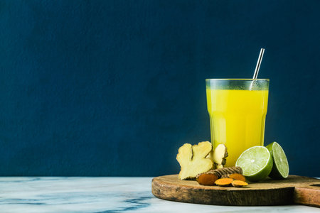 golden ginger and turmeric drink with lime juice. Healthy anti-inflammatory drink of natural...