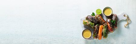 banner of vegan rainbow summer rolls in rice wrapper with spicy almond sauce. healthy foodの写真素材