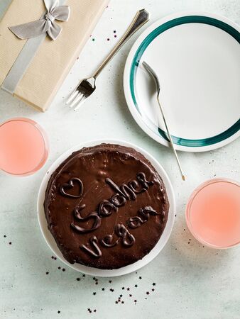 vegan festive chocolate sacher cake with apricot jam on the table. written by chocolateの写真素材