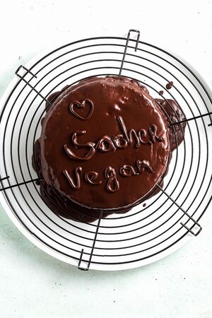 vegan festive chocolate sacher cake with apricot jam on the table. written by chocolateの写真素材