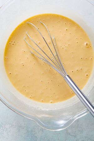 ready batter in a glass bowl for frying vegetables in oilの写真素材