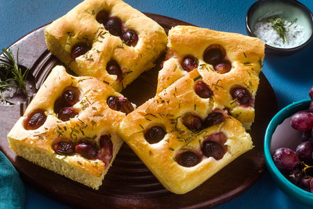 focaccia with red grapes on a blue table. Italian Cuisine, the perfect appetizerの写真素材