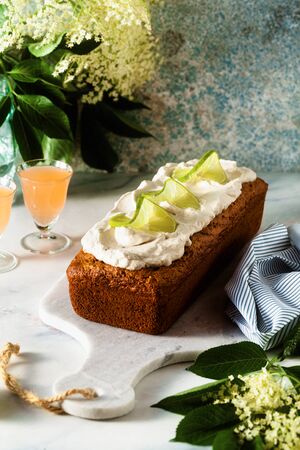 summer sweet loaf cake on a table with flowers and a drink in glasses. dessert for brunch or morning breakfastの写真素材