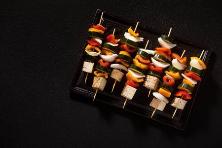 vegan kebabs of vegetables and smoked tofu, in a baking sheet, ready for baking in the ovenの写真素材