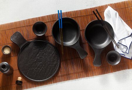 set of black empty japanese breakfast tableware on bamboo matの写真素材