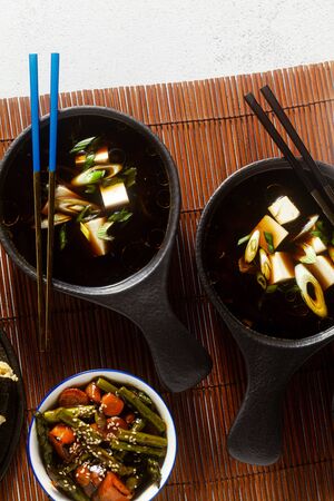 Japanese breakfast with miso soup, onigiri and vegetables in sweet and sour sauce. Typical traditional morning foodの写真素材