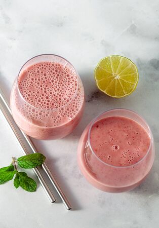morning sweet breakfast smoothie based on oat milk, banana and raspberries, with lime juiceの写真素材