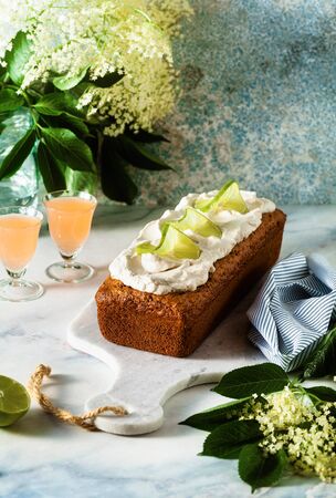 summer sweet loaf cake on a table with flowers and a drink in glasses. dessert for brunch or morning breakfastの写真素材