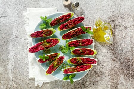 dip of boiled beets and pistachios in leaves of Belgian Endive with mint. healthy summer snackの写真素材