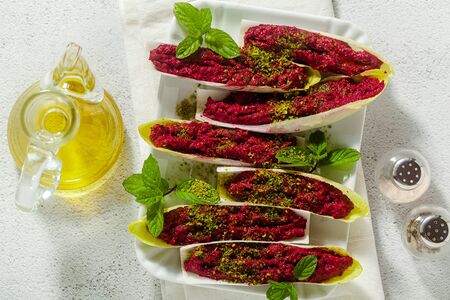 dip of boiled beets and pistachios in leaves of Belgian Endive with mint. healthy summer snackの写真素材