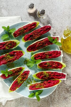 dip of boiled beets and pistachios in leaves of Belgian Endive with mint. healthy summer snackの写真素材