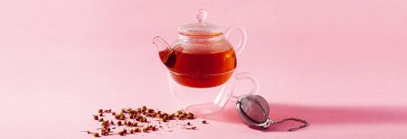 banner of tea in a glass teapot on a pink background and a metal Infuser Filterの写真素材