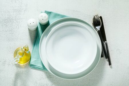 empty plates on a blue napkin and white background. porcelain setの写真素材