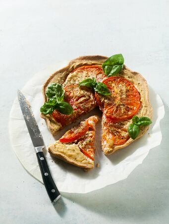 summer vegan pie galette with tomatoes and tofu in oat milk. tasty snack or healthy food lunchの写真素材