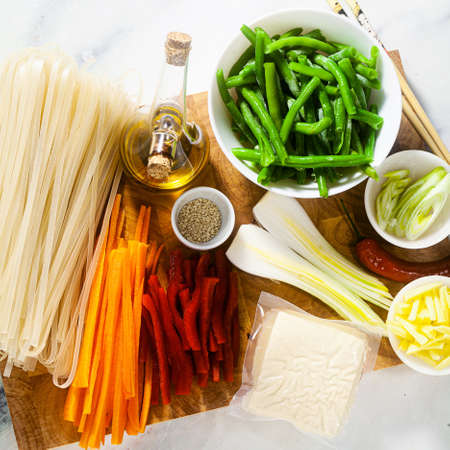 Pad Thai ingredients on a cutting board on a white marble tableの写真素材
