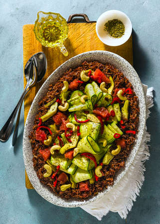 summer salad of red rice, fresh zucchini and grapefruit with hot pepper and cashew on a blue backgroundの写真素材