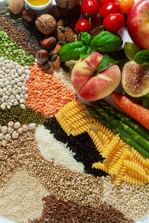 basic vegan ingredients and products. cereals, legumes, fresh vegetables and fruits, oils, seeds and nuts. balanced healthy diet isolated on whiteの写真素材