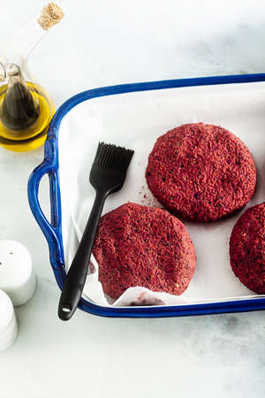 raw vegan cutlets for burger without meat on a baking sheet on a tableの写真素材
