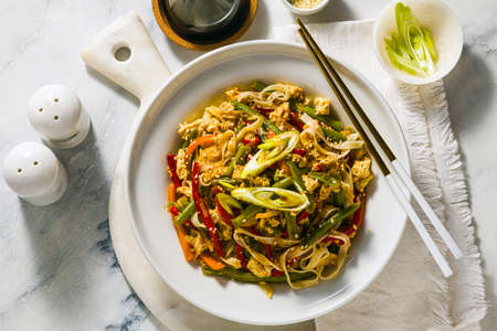 Thailand street food - Pad Thai with tofu in a plate on a table, in a restaurant or cafeの写真素材