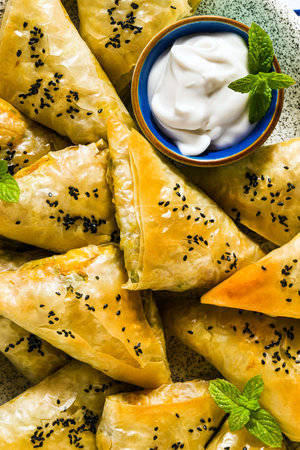 indian samosa made with phyllo with spicy potatoes and vegetables , served with yogurt, mint and...