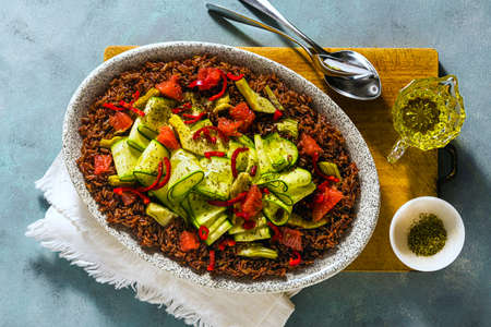summer salad of red rice, fresh zucchini and grapefruit with hot pepper and cashew on a blue backgroundの写真素材