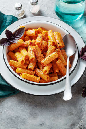pasta with baked peppers and cashews sauce. vegan full-fledged healthy lunch or dinner with purple basilの写真素材