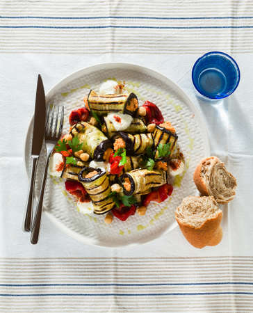 grilled eggplant wrap with red bell pepper hummus and spicy yogurt on the table. delicious vegan recipeの写真素材
