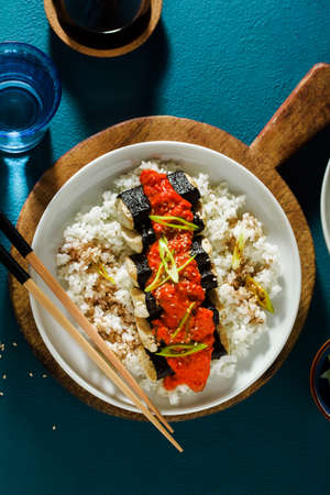 fried tofu wrapped in nori with tomato-coconut sauce and rice for sushi. vegan modern cuisineの写真素材