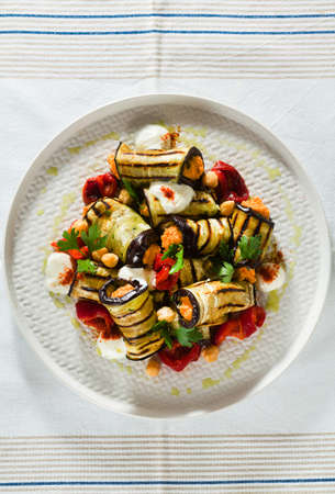 grilled eggplant wrap with red bell pepper hummus and spicy yogurt on the table. delicious vegan recipeの写真素材