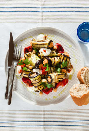 grilled eggplant wrap with red bell pepper hummus and spicy yogurt on the table. delicious vegan recipeの写真素材