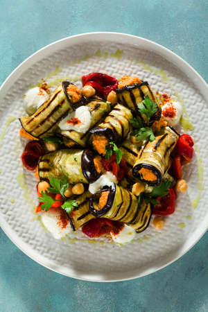 grilled eggplant wrap with red bell pepper hummus and spicy yogurt on the table. delicious vegan recipeの写真素材
