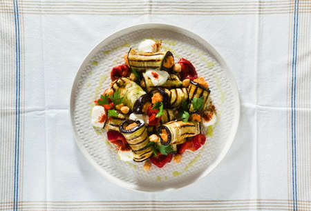 grilled eggplant wrap with red bell pepper hummus and spicy yogurt on the table. delicious vegan recipeの写真素材
