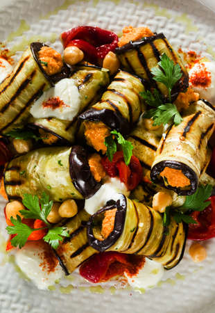 grilled eggplant wrap with red bell pepper hummus and spicy yogurt on the table. delicious vegan recipeの写真素材