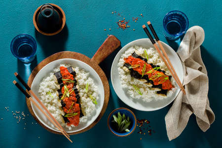 fried tofu wrapped in nori with tomato-coconut sauce and rice for sushi. vegan modern cuisineの写真素材
