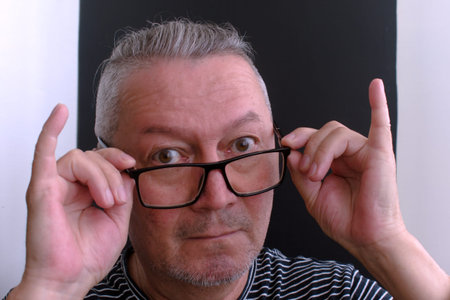 portrait of middle aged man with glasses looks surprised