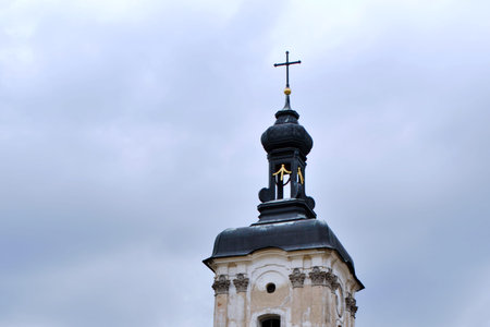 catholic cathedral tower on gray clouds sky background