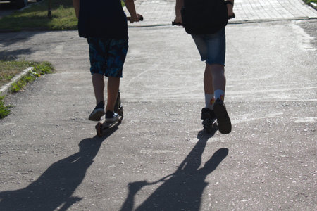 shadows catch up with boys on scooters
