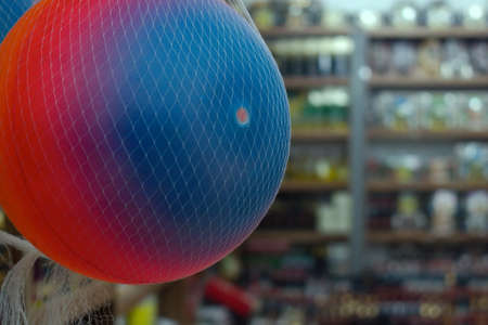 inflatable multi-colored silicone ball in net on blurred background of store interiorの写真素材