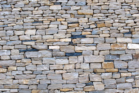 textured wall of flat cobblestone in different colors and sizesの写真素材