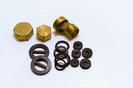 brass plugs and joints and rubber gaskets for repairing plumbing on white backgroundの写真素材