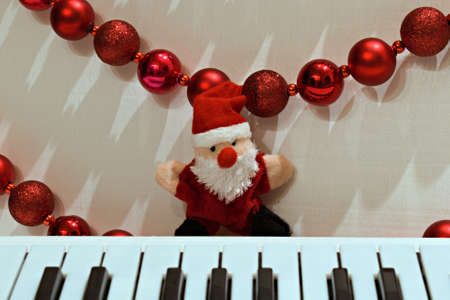 funny santa claus toys on blurred background of piano and christmas garlandの写真素材