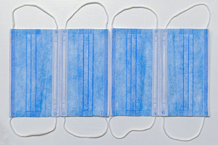 template of four disposable face masks on white painted background