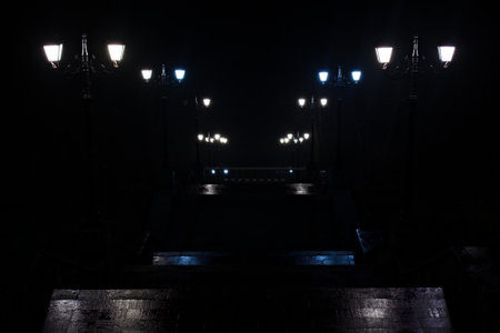 bright lanterns in park on stairs that going down in the darkの写真素材