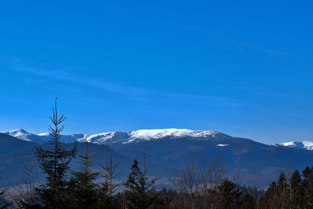 Snowy mountain peaks in sunlight against blue sky backgroundの写真素材